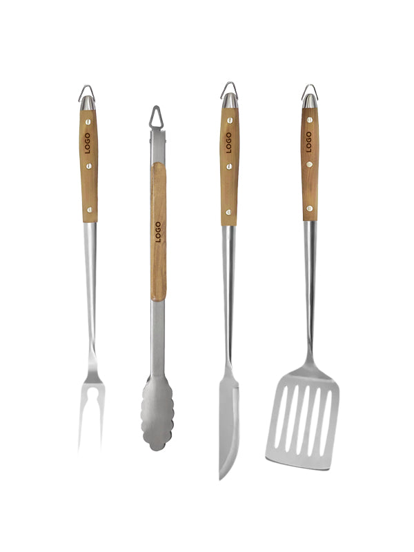 Four stainless steel outdoor grilling tools with light wood handles, including a fork, tongs, skewer knife, and spatula, arranged side by side on a white background.