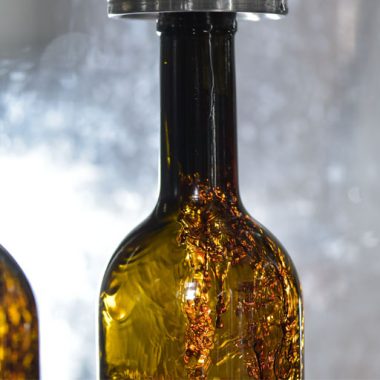 Wine bottle close-up, being filled with wine on bottling line