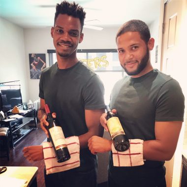 Two men holding wine bottles