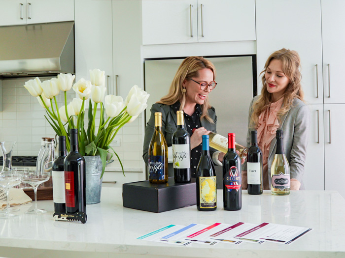 A Wine Consultant in a Host's kitchen showing and describing wines