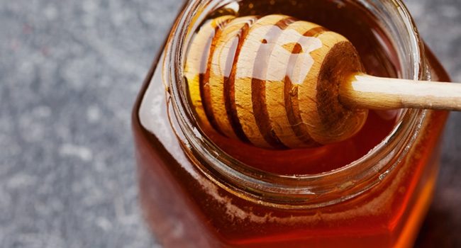 Jar of honey with stirrer