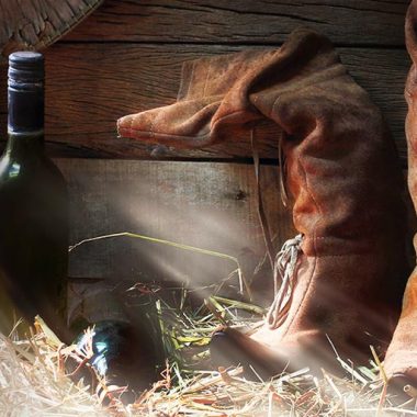 Wine and cowboy boots in a barn