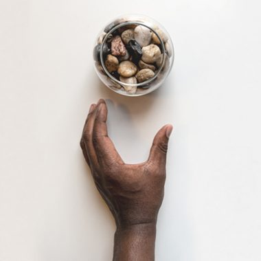 Pebbles in a glass with a hand
