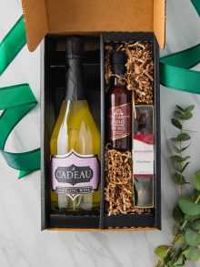 Gift box with sparkling wine, chocolate truffles and chocolate sauce
