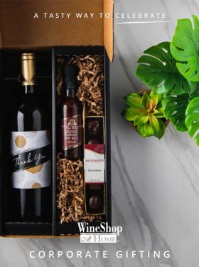 Top-down image of gift box with Thank You red wine, chocolates and chocolate sauce