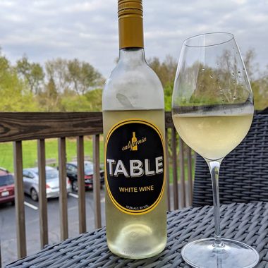 A chilled glass and bottle of Table White Wine on balcony table