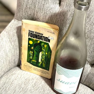A chilled bottle of Suavé Bang Sparkling Wine next to an original copy of "Foundation"