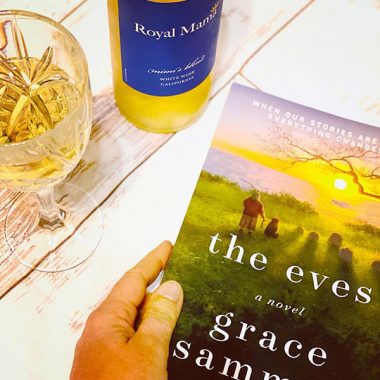 A filled glass and bottle of Royal Mama Mimi's Blend next to a paperback copy of "The Eves"