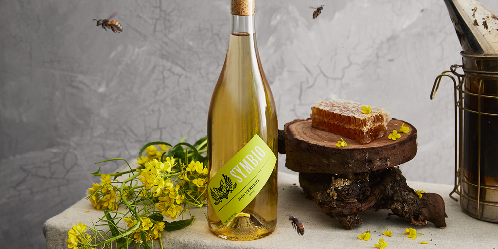 Symbio Verdejo white wine pictured with flowers, honeycomb and bees.