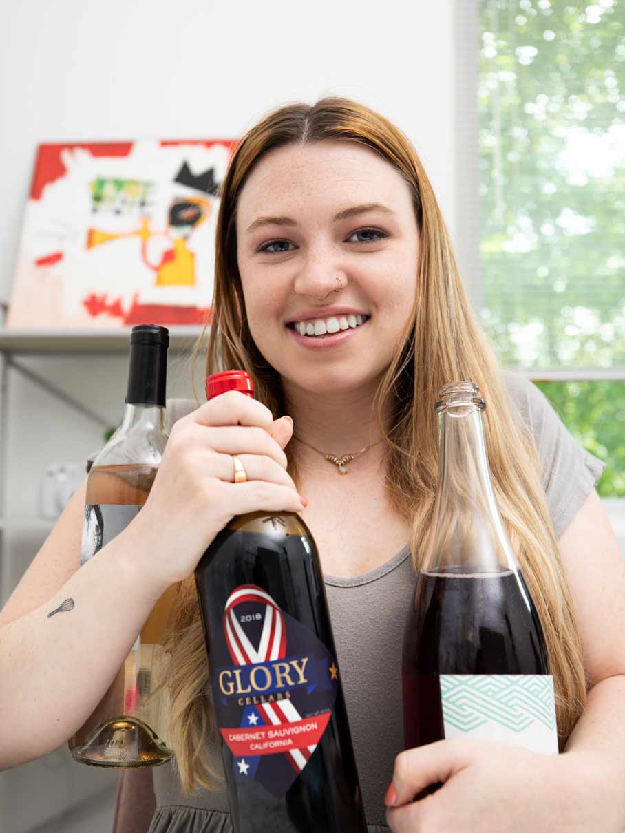 Woman holding three bottles of wine
